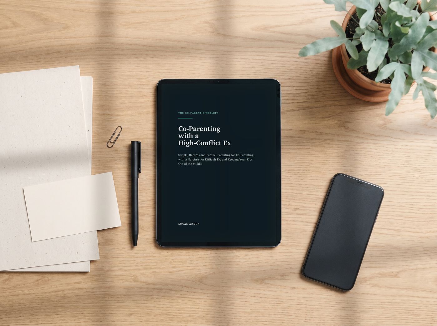 The toolkit on a desk: the guide on a tablet, printed log sheets, a script card and a pen.